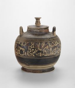 Image of Pyxis (container for personal objects), C. 580-570 B.C.E. The description from the Art Institute reads, "Around the time that this jar was made, Egypt’s king, Amasis (r. 570–526 B.C.), in the interest of trade, gave the Greeks the Egyptian port city of Naucratis, where Greek and Egyptian cultures mingled. The small sphinx on this jar is indicative of this cultural encounter, as Greeks would have been familiar with the part human, part-lion creatures, which lined the entryway to most Egyptian temples. Including a sphinx on this jar added a touch of the exotic East, which would have appealed to the citizens of Corinth. The identities of most Greek vase painters are unknown, so sometimes they are named after a distinctive feature. The artist who decorated this container is called the Ampersand Painter because here and elsewhere the looping tail of the sphinx (a winged feline with a human head) takes the shape of an ampersand, the proper name for the symbol &, which is shorthand for the word “and” (Art Institute of Chicago, 2021).