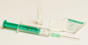 A picture of a syringe, vial, and alcohol pad